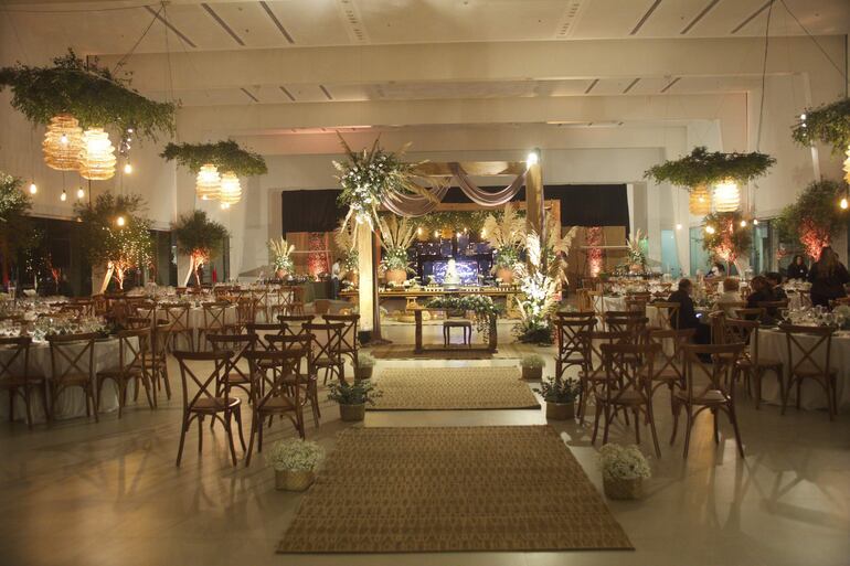 La ceremonia civil y la fiesta de bodas fueron en el salón Socios Veteranos de la Guerra del Chaco del Club Centenario, que fue decorado en tonos tierra, usando elementos de la naturaleza y texturas secas para lograr un ambiente diferente y cálido. 
