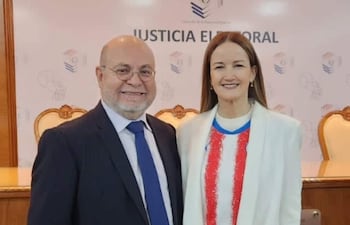Luis Fretes Carreras, hombre calvo con gafas, y Soledad Núñez, mujer con cabello suelto, sonríen en un entorno institucional.