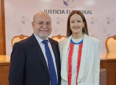 Luis Fretes Carreras, hombre calvo con gafas, y Soledad Núñez, mujer con cabello suelto, sonríen en un entorno institucional.