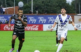 El uruguayo Lucas Morales (i), futbolista de Olimpia, disputa el balón en un partido frente a Sportivo Ameliano por la cuarta fecha del torneo Clausura 2025 de la Primera División de Paraguay en el estadio Ameliano Villeta, en Villeta, Paraguay.