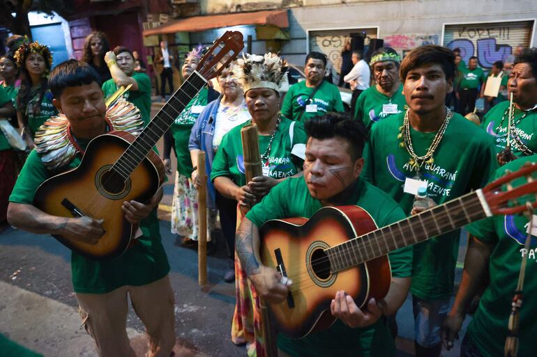 Integrantes de la comunidad indígena Ava Guaraní Paranaense interpretan instrumentos durante una manifestación.