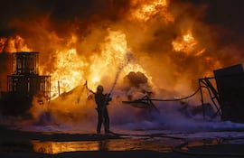 Bomberos trabajan en el lugar de un bombardeo ruso en Kiev, Ucrania, ayer jueves.