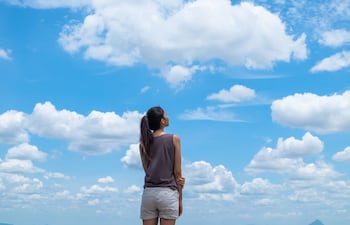 Mujer observa el cielo azul.