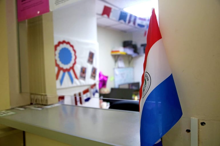 Bandera de Paraguay en primer plano, con decoraciones festivas en el fondo, sin personas visibles.