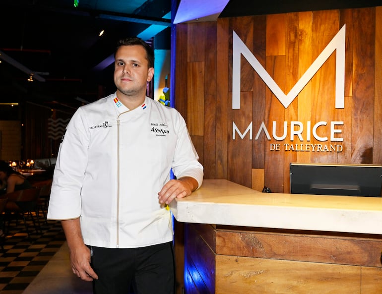 Chef Inaki Aldrey en chaqueta blanca junto a un mostrador de restaurante, con un ambiente moderno y acogedor.