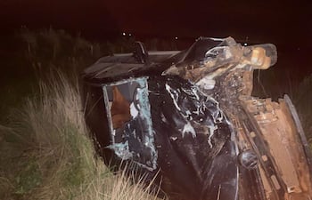 Vehículo volcado en terreno rural con daños significativos, rodeado de vegetación, sin presencia de personas en escena.