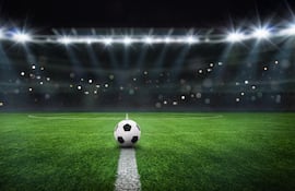 Imagen ilustrativa. Una pelota de fútbol sobre la línea que marca al mitad de una cancha.