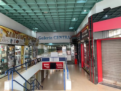 Interior de la Galería Central vacío, con vitrinas de productos electrónicos y un ambiente moderno y desolado.