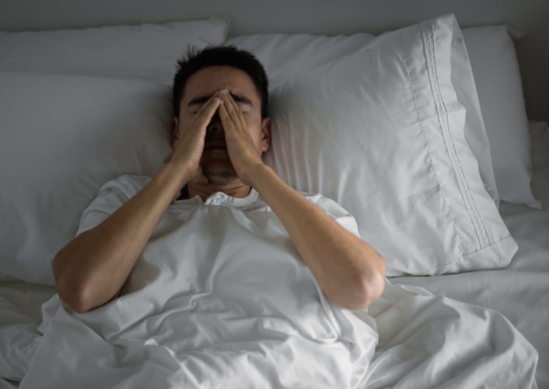 Hombre frustrado en la cama, imagen ilustrativa.