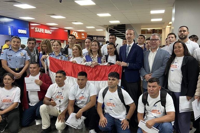 El embajador de España en Paraguay, Javier Parrondo (3-d) junto a la viceministra de Empleo y Seguridad Social, Verónica López (c), posan junto a trabajadores este lunes, en el Aeropuerto Internacional Silvio Pettirossi en Luque (Paraguay). 
