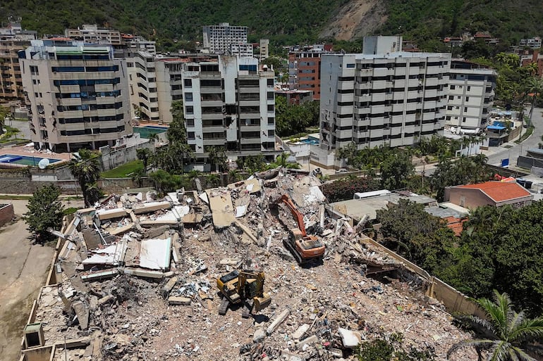 Esta vista aérea muestra excavadoras trabajando en las ruinas de edificios destruidos por los terremotos del 24 de junio cerca de Playa Escondida, en Taraguanera (estado de La Guaira, Venezuela)