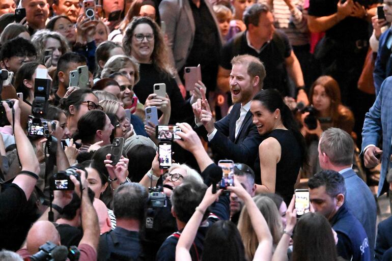 El príncipe Harry y su esposa Meghan saludan sonrientes y felices a la gente en el Royal Children's Hospital de Melbourne. (William WEST / AFP)