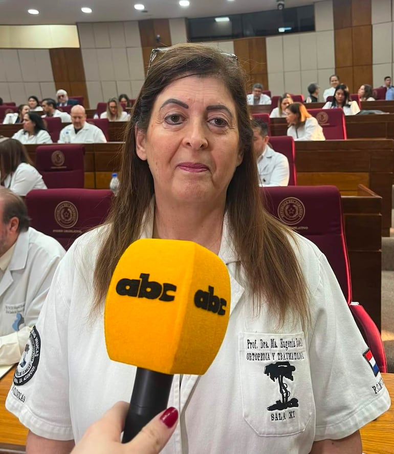 Ma Eugenia Bocelli, con cabello castaño y camisa blanca, habla frente a un micrófono, mientras una audiencia atenta la observa.