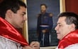 Santiago Peña y Horacio Cartes en camisas blancas con banda roja, ajustando distinción en ambiente institucional y formal.