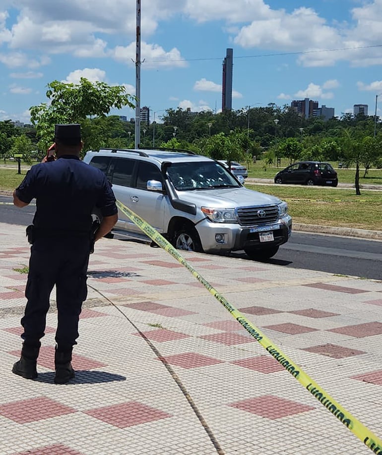 Un policía observa la camioneta que fue emboscada por un motochorro.