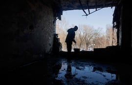 Un hombre limpia de escombros una clínica médica privada dañada por un dron ruso en Kiev, ayer lunes.