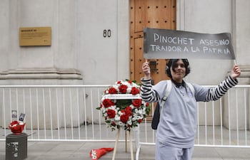 Una persona sostiene un cartel durante la conmemoración de los 53 años del golpe de Estado, este viernes frente al el Palacio de La Moneda en Santiago (Chile).