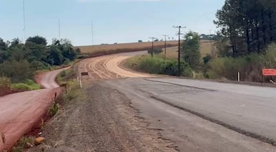 Intersección de caminos rurales con señal 'ATENCIÓN, OBRA' y vegetación alrededor, sin personas presentes.