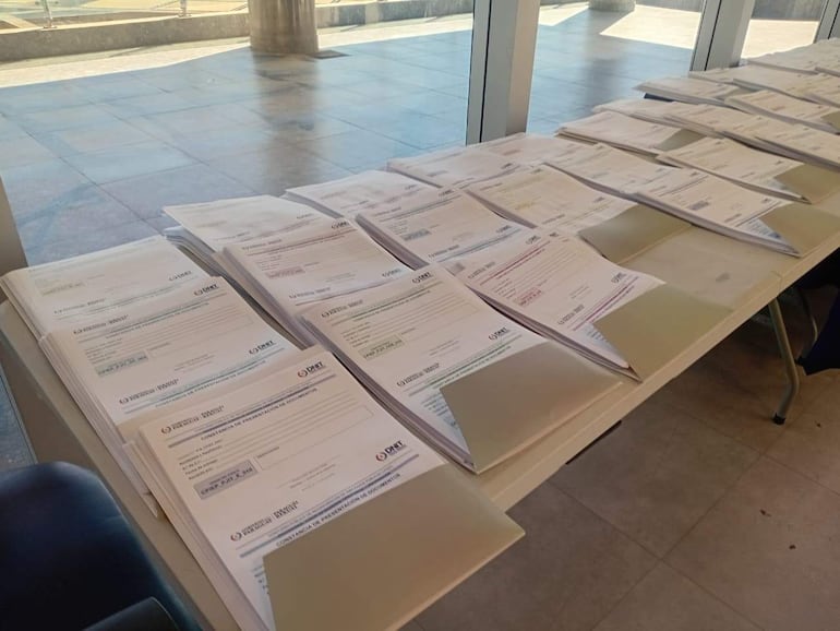Documentos organizados en mesa con encabezados y logotipos visibles en un ambiente institucional.