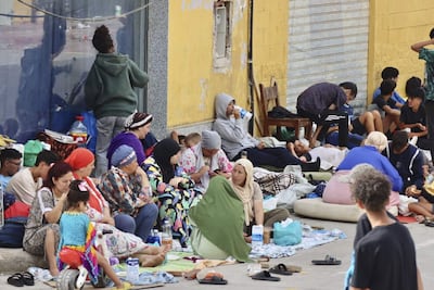 Cientos de inmigrantes marroquíes descansan en las calles de Ceuta, este lunes. La vigilancia en el entorno de la frontera del Tarajal, tanto por vía marítima como terrestre, así como los nuevos medios de contención en la zona con la instalación de una barrera en el mar han reducido al mínimo las entradas a nado desde Marruecos.