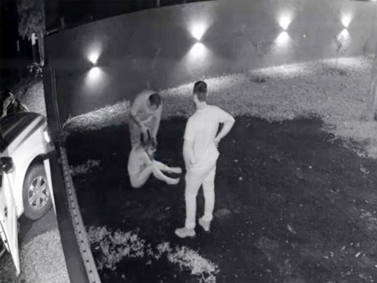 El torturador coloca una pistola en la cabeza de la mujer, siempre observado por el marido de ella.