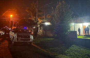 Policía en calle con camionetas blancas y personas reunidas frente a una casa iluminada en Cambyretá.