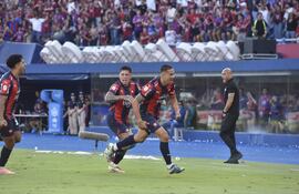 El zaguero Víctor Gustavo Velázquez sale a festejar el tanto de apertura en el marcador, acompañado por Juan Manuel Iturbe, que desató la euforia azulgrana.