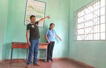 El padre de familia Ismael Ortega y la secretaria de la institución Norma Guillen mostrando las enormes grietas en las paredes.