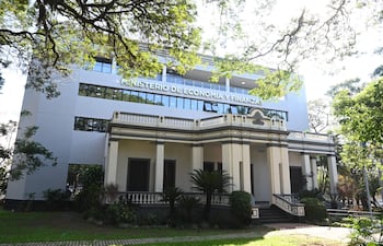 Edificio moderno y clásico del Ministerio de Economía y Finanzas, rodeado de vegetación y jardines bien cuidados.