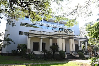 Edificio moderno y clásico del Ministerio de Economía y Finanzas, rodeado de vegetación y jardines bien cuidados.