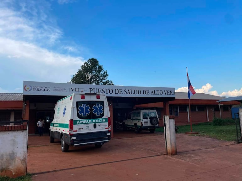 Ambulancia con distintivos oficiales frente al Puesto de Salud de Alto Verá, rodeada de vegetación y bajo un cielo nublado.