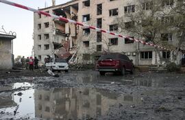 Rescatistas ucranianos y pobladores locales permanecen en el lugar de un ataque ruso contra una zona residencial en Zaporiya, en el sureste de Ucrania