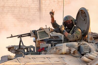 Un soldado israelí saluda desde la torreta de un transporte militar cerca de la frontera con la Franja de Gaza, en el sur de Israel.