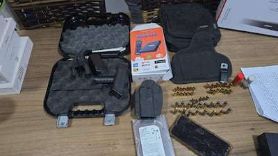 Objetos incautados incluyen un estuche negro, balas y un dispositivo de TV en una superficie de madera.