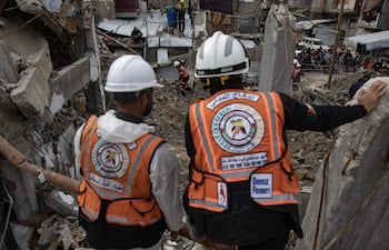 Rescatistas trabajan en la búsqueda de cuerpos entre los escombros de edificios destruidos por bombardeos israelíes en Jan Yunis, en el sur de la Franja de Gaza.