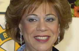 Gladys Bareiro de Módica sonríe, lleva pendientes y collar, en un retrato formal con fondo neutro.
