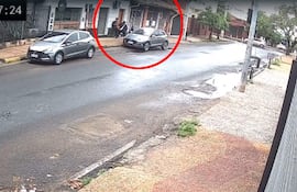 Dos personas de espaldas frente a un local, con cielo nublado y charcos en la calle tras haber llovido.