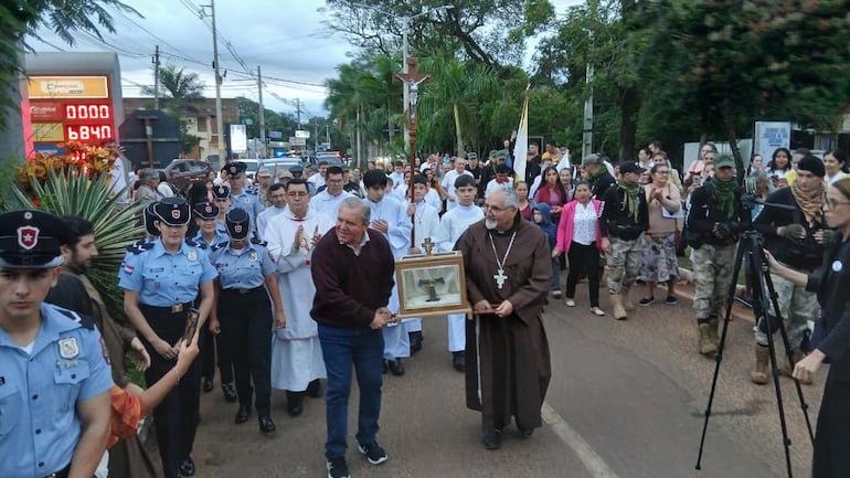 El comunicador Roberto Herve Benítez y monseñor Marcelo Benítez llevan en andas la pequeña urna que contiene la reliquia.