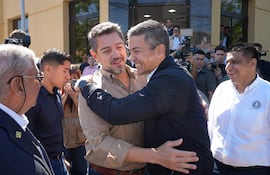 Pedro Alliana (izq.) y Santiago Peña se abrazan efusivamente, esta mañana en un acto oficial en la ciudad de Caacupé, dónde el mandatario hizo día de gobierno. Luego, ambos se trasladaron a Itacurubí de la Cordillera.