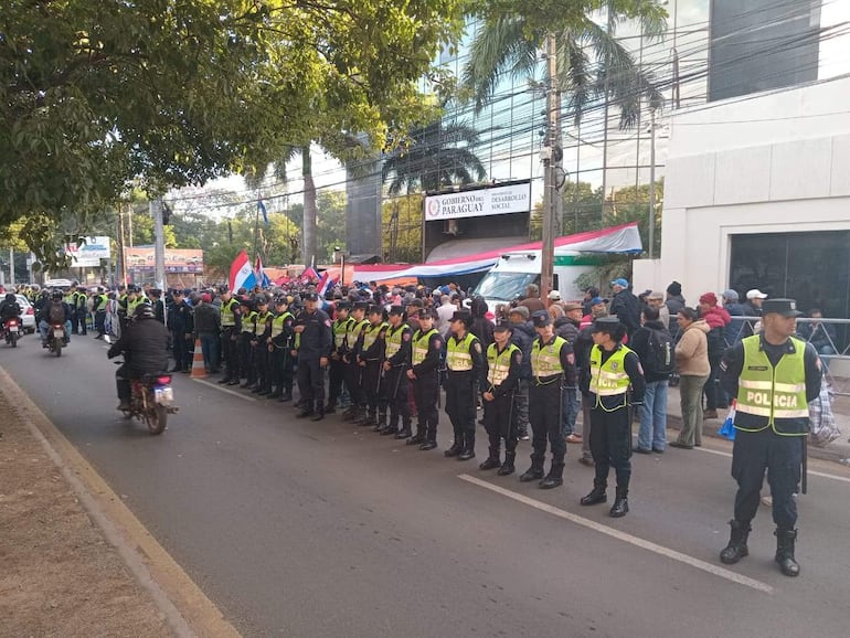 Agentes de policía con chalecos reflectantes resguardan la protesta de adultos mayores frente al Ministerio de Desarrollo Social.