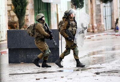 Soldados israelíes toman posiciones durante enfrentamientos con palestinos en la ciudad cisjordana de Hebrón, el 25 de marzo de 2022.