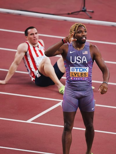  César Almirón Escobar tendido en el fondo luego de su corrida, enfrente festejando el estadounidense Noah Lyles ganador de la serie.