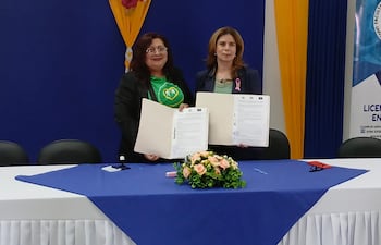 La presidenta de la Asociación de Adultos Mayores, Cristina Ozuna y la decana de la Facultad de Ciencias Biomédicas de la Universidad Nacional de Pilar (UNP) Raquel Echeverria exhiben el documento de acuerdo de cooperación luego de la firma.