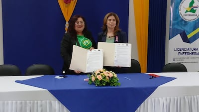 La presidenta de la Asociación de Adultos Mayores, Cristina Ozuna y la decana de la Facultad de Ciencias Biomédicas de la Universidad Nacional de Pilar (UNP) Raquel Echeverria exhiben el documento de acuerdo de cooperación luego de la firma.