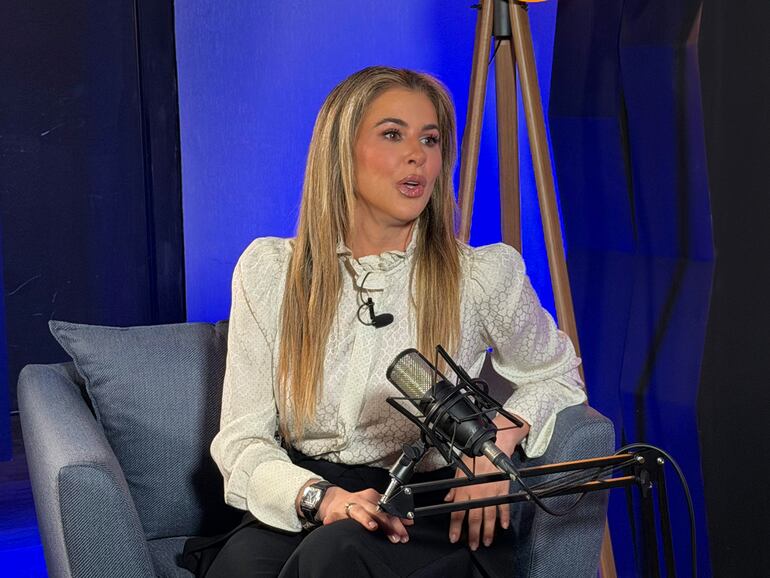 Fátima Agüero sentada en sillón, con blusa clara y pantalones oscuros, discutiendo temas de salud frente a un micrófono en un ambiente profesional.