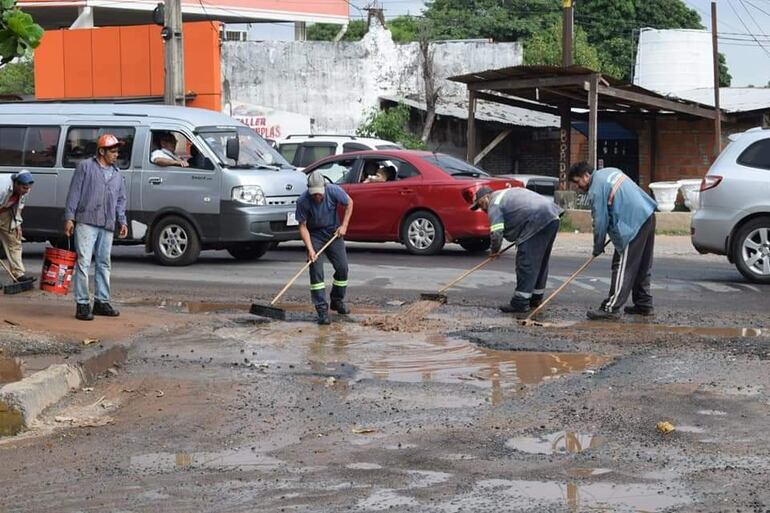 Municipios buscan mantener en buen estado la avenida Defensores del Chaco. Trabajadores de la municipalidad de Villa Elisa reparan la banquina que se encuentra minada de baches.