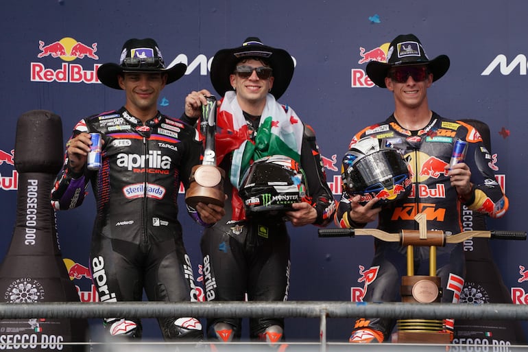 El italiano Marco Bezzecchi (centro) celebra en el podio su triunfo junto a los españoles Jorge Martín (izquierda) y Pedro Acosta. 