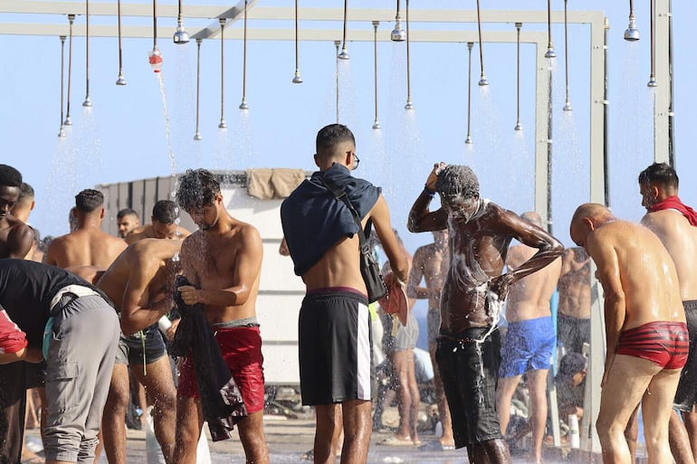 CEUTA, 25/08/2026.- Multitud de migrantes continúan acampados en la playa de El Trampolín este martes. EFE/ Reduan