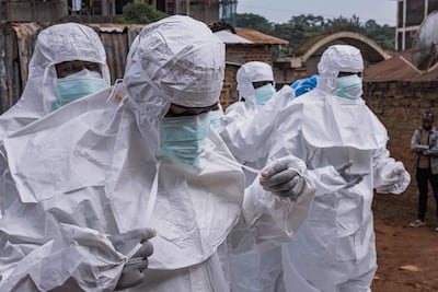 Trabajadores de la Sociedad de la Cruz Roja de Uganda se colocan trajes de protección mientras se preparan para evacuar el cuerpo de una presunta víctima de ébola en Kampala el 26 de mayo de 2026.