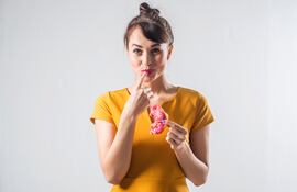 Mujer comiendo una masa dulce.